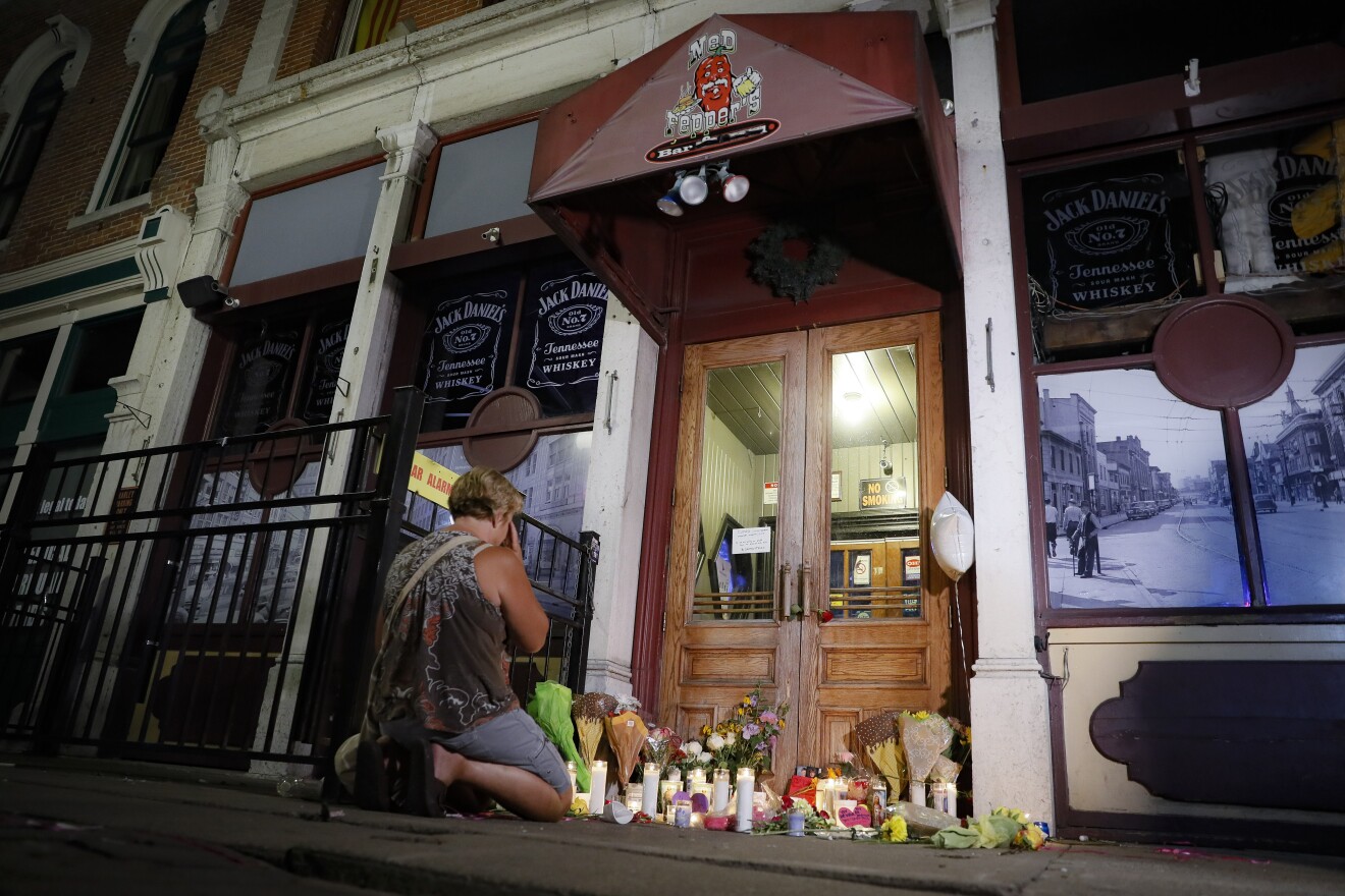 Mourners visit a makeshift memorial outside Ned Peppers bar following a vigil at the scene of the mass shooting early Sunday morning in Dayton, Ohio. 